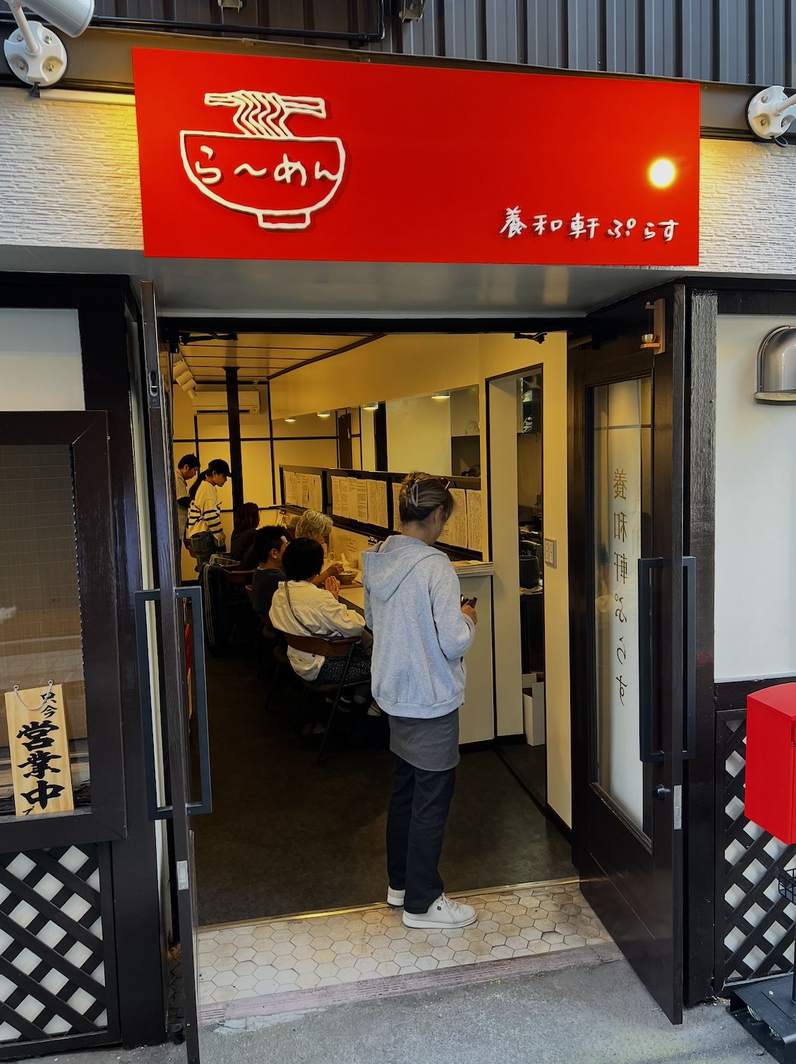 夜の養和軒ぷらす。赤い看板とラーメンののぼり